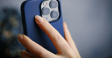 la main d'une femme qui tient un iphone 13