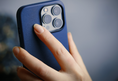la main d'une femme qui tient un iphone 13